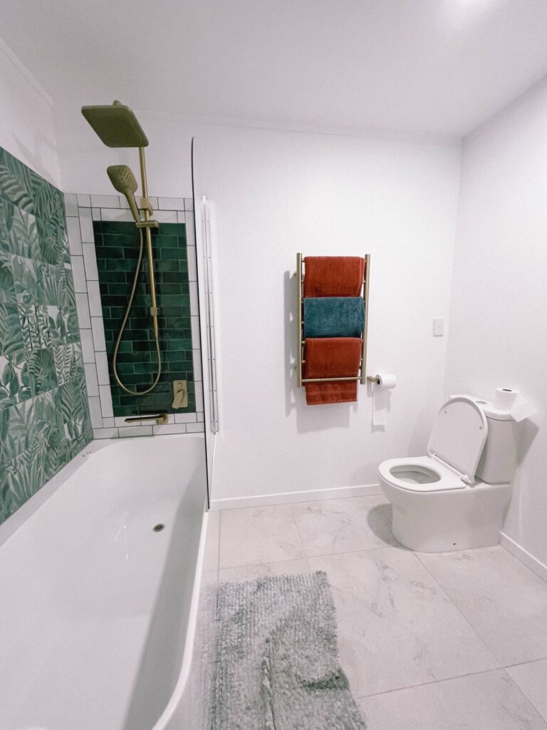 Felujitott modern furdoszoba zold csempevel