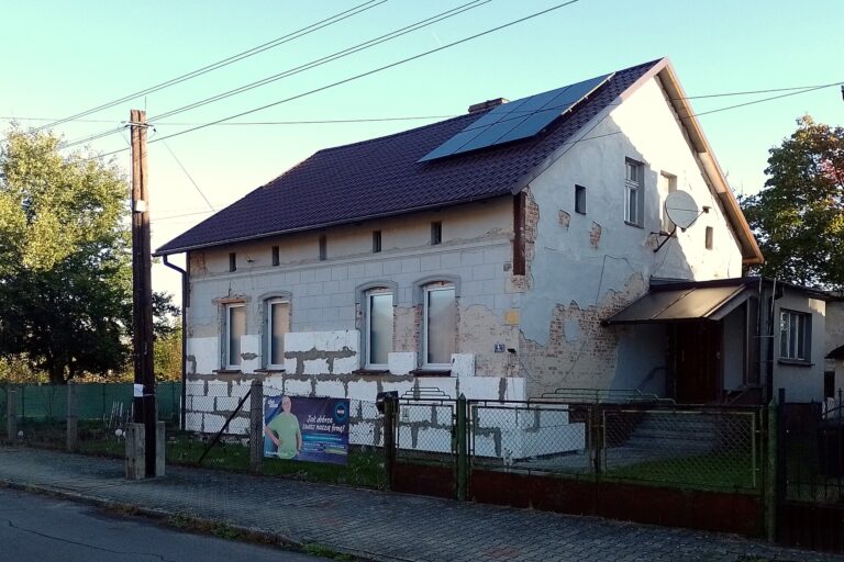 Félbehagyott homlokzati hőszigetelés egy családi házon, szabadon maradt téglafallal